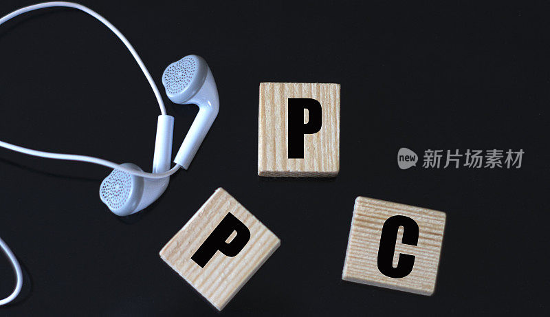 PPC -首字母缩略词在一个黑色背景上的木制立方体与耳机